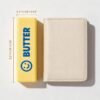 Hand holding a NeeDoh Butter Squishy realistic slow-rise butter stick toy — Image 7 of 11