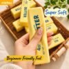 Hand holding a NeeDoh Butter Squishy realistic slow-rise butter stick toy — Image 4 of 11