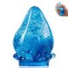 Blue NeeDoh Dream Drop raindrop squish toy resting on its clear splash-shaped stand — Image 1 of 7